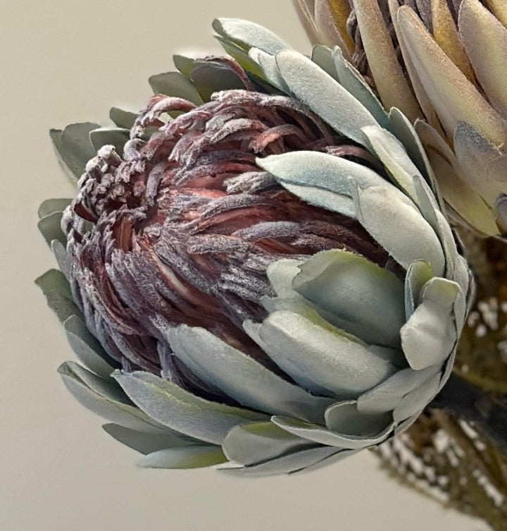 Close view of the blue-green king protea faux flower