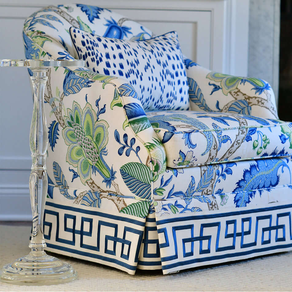 Elegant living room with a Sculptural Crystal Pedestal Table beside a floral upholstered chair in a vibrant blue and green pattern.