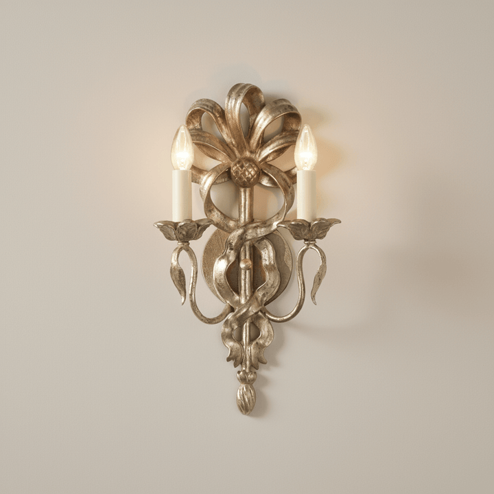 Decorative wall sconce with two lit lights on a plain wall.