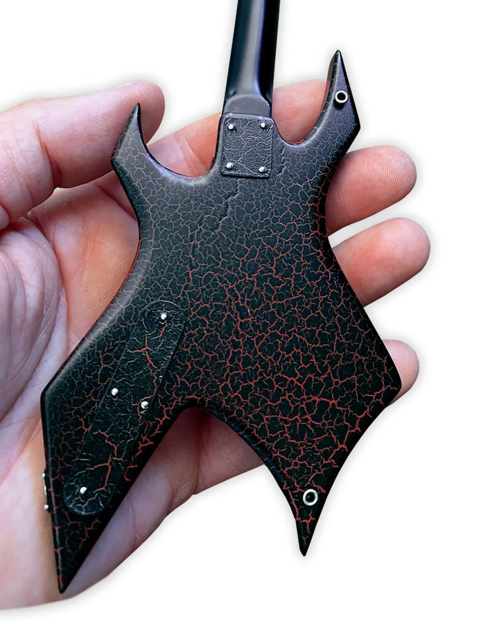 Hand holding Stranger Things Eddie’s B.C. Rich Warlock Mini Guitar Replica showing detailed back design.