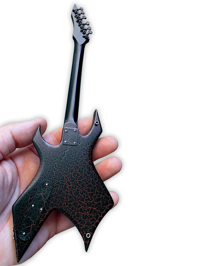 Hand holding Stranger Things Eddie’s B.C. Rich Warlock Mini Guitar Replica, a detailed collectible inspired by Eddie Munson's guitar solo.