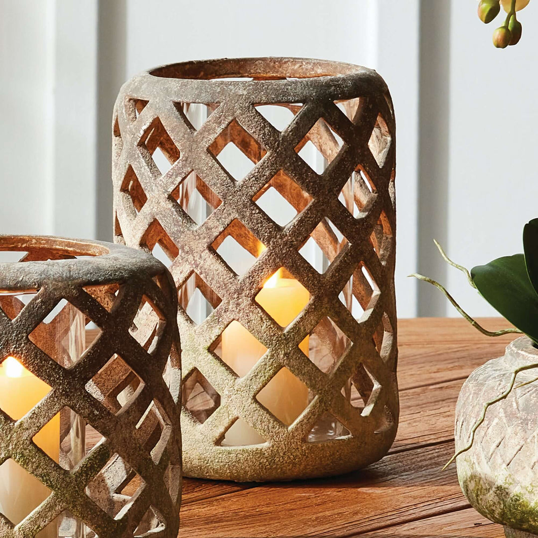Terracotta hurricane candle holder with glass insert, featuring a lattice design and soft flickering candlelight