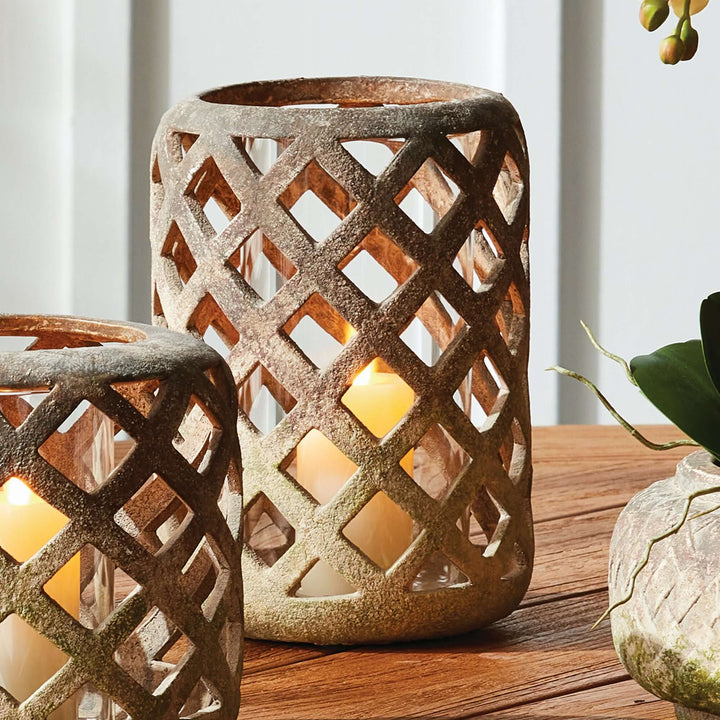 Terracotta hurricane candle holder with glass insert, featuring a lattice design and soft flickering candlelight