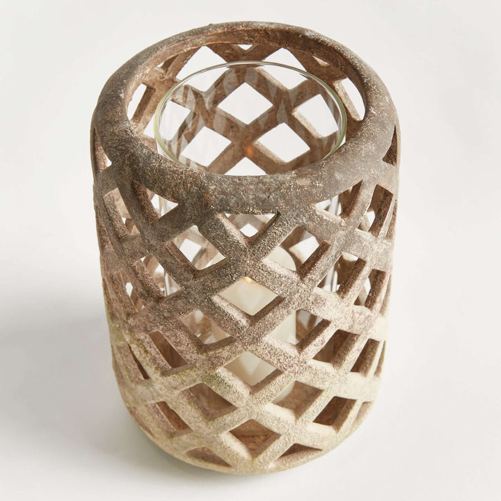 Terracotta hurricane candle holder with glass insert featuring airy lattice design, perfect for tea lights and small candles.