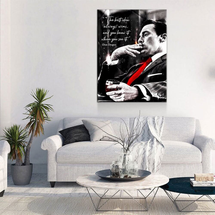 Don Draper “The Best Idea Always Wins” Canvas Wall Art hanging above a modern living room sofa with plants and a coffee table.