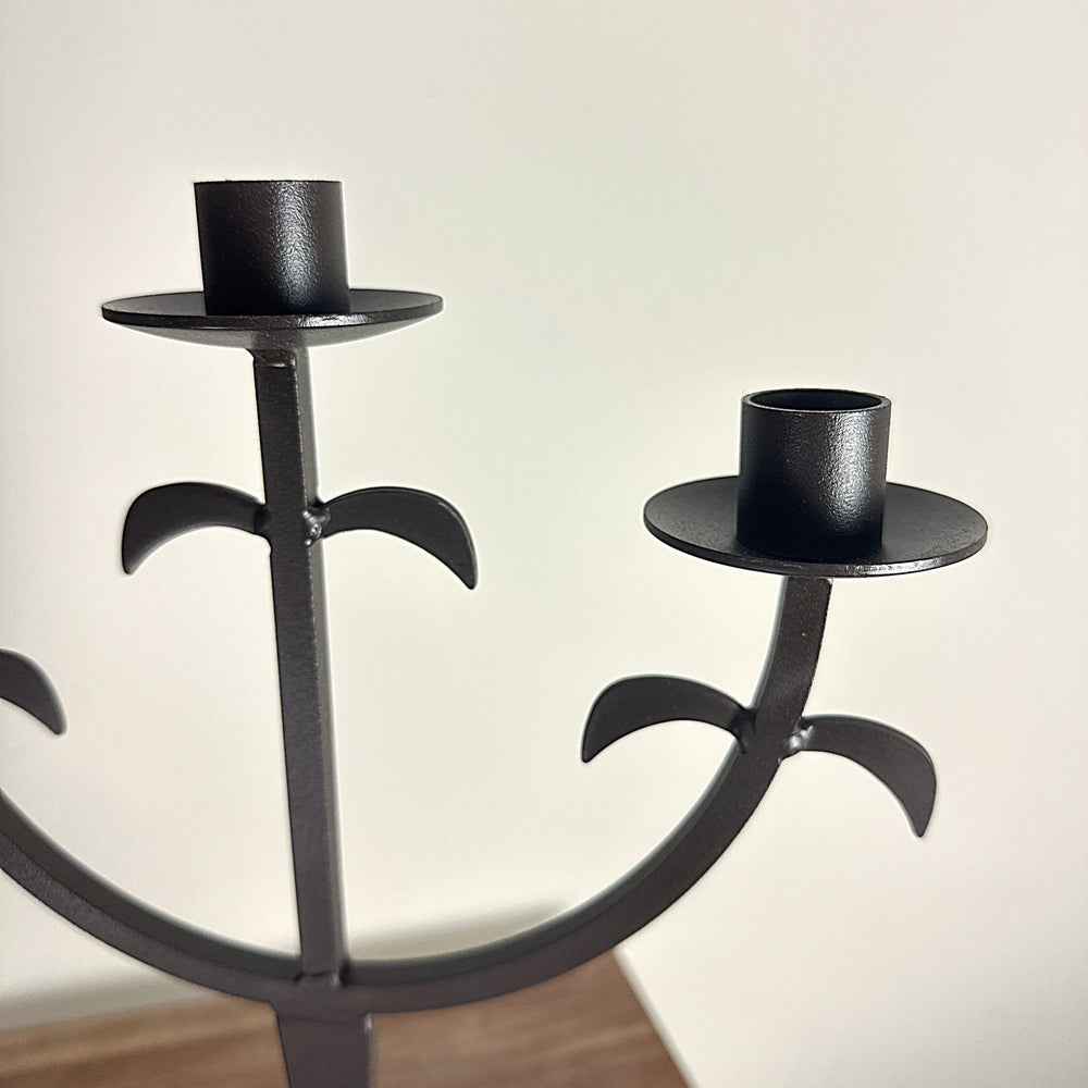 Close view of curved arms and drip plates on Three-Arm Iron Candelabra
