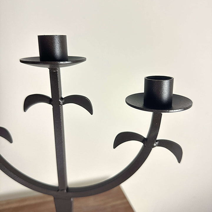 Close view of curved arms and drip plates on Three-Arm Iron Candelabra