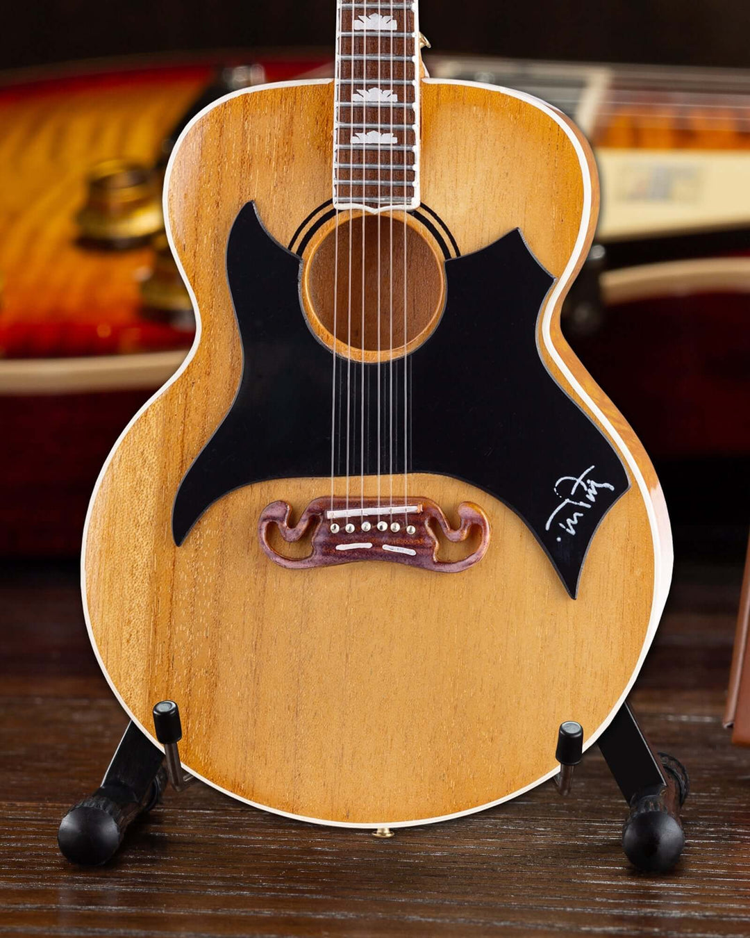 Tom Petty Gibson SJ-200 Wildflower Mini Guitar Replica on a stand.