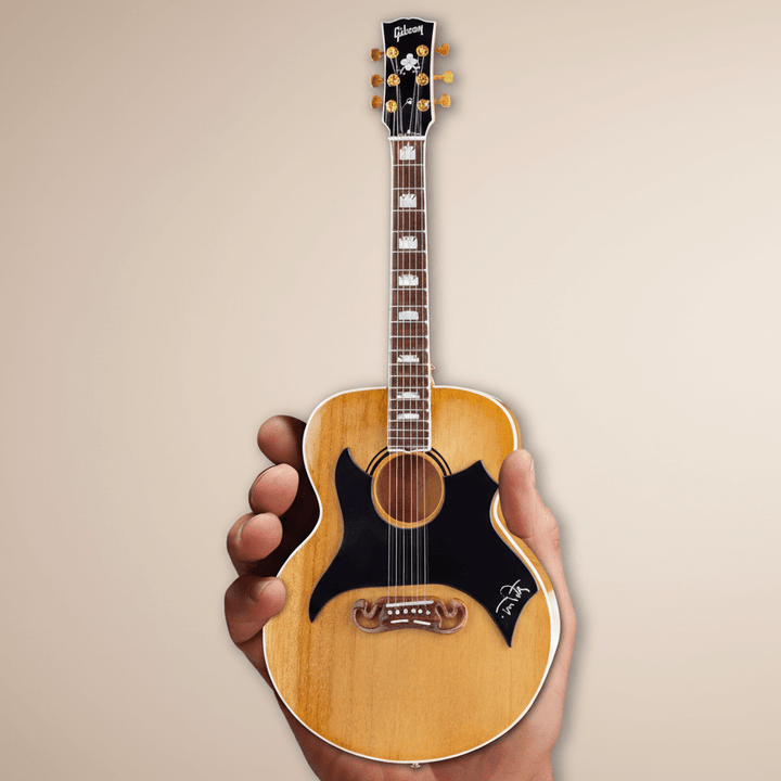 Hand holding Tom Petty Gibson SJ-200 Wildflower Mini Guitar Replica, showcasing detailed craftsmanship.