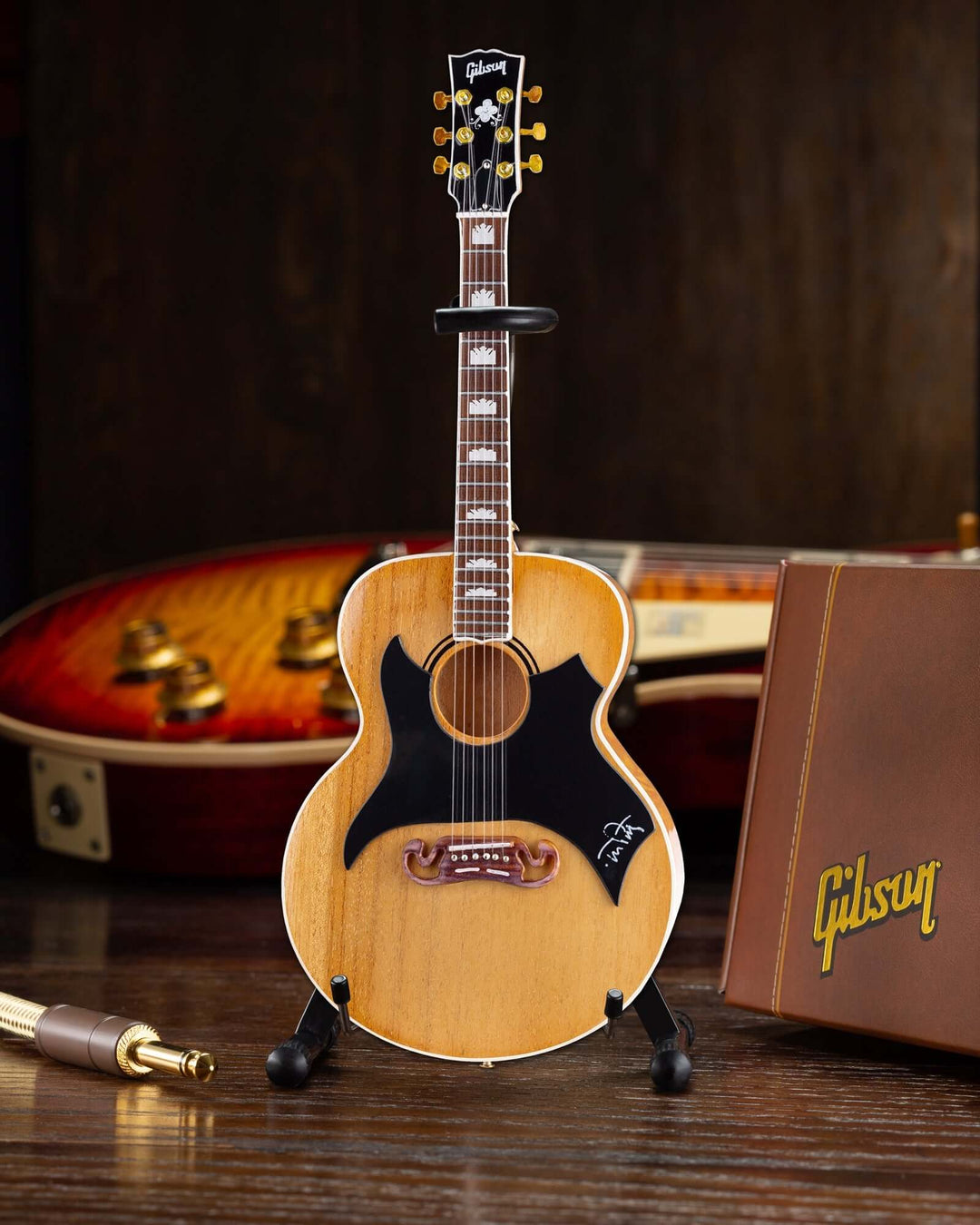 Tom Petty Gibson SJ-200 Wildflower Mini Guitar Replica on display with Gibson packaging in background.