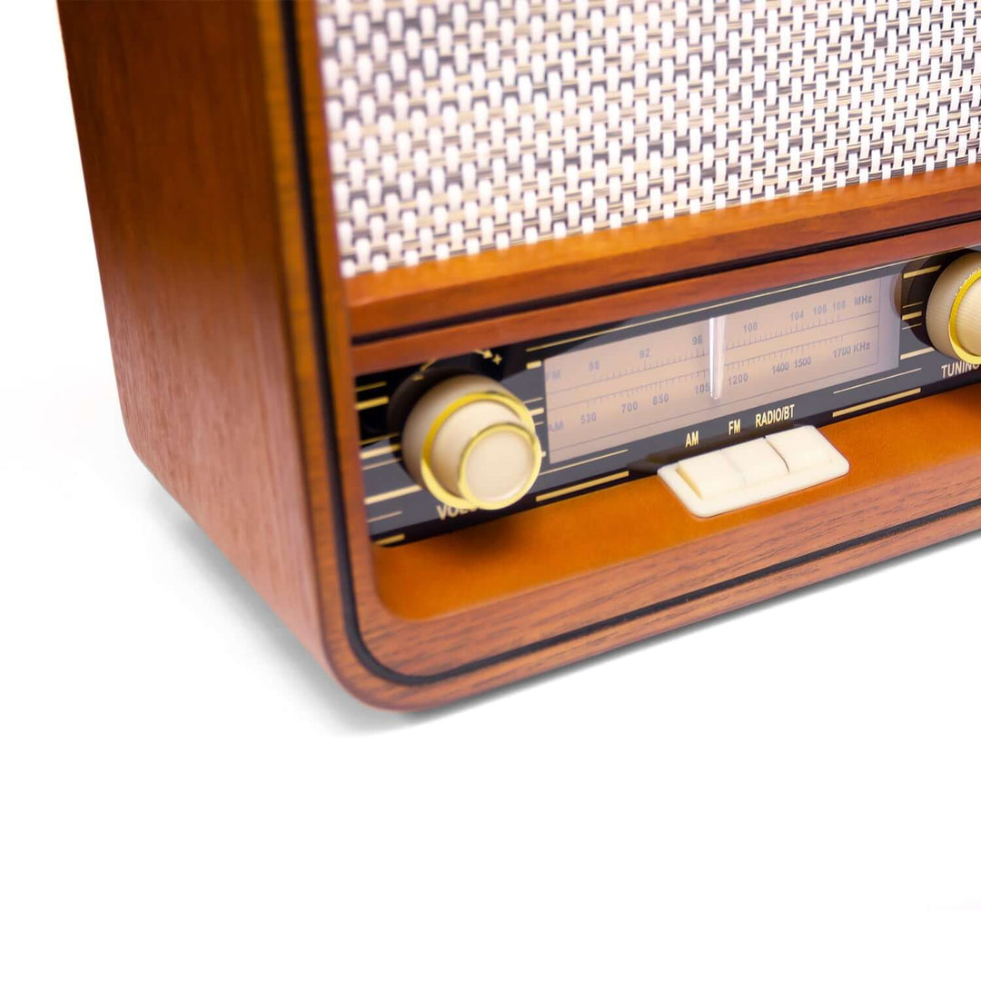 Close-up of a vintage-style radio with wooden casing and metallic components on a white background.