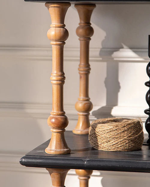 Close-up of the warm turned wood supports and contrasting dark shelf