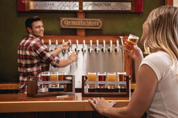 Rustic Craft Beer Flight Tasting Set displayed on a bar with handcrafted acacia wood tray and glasses in a brewery setting.