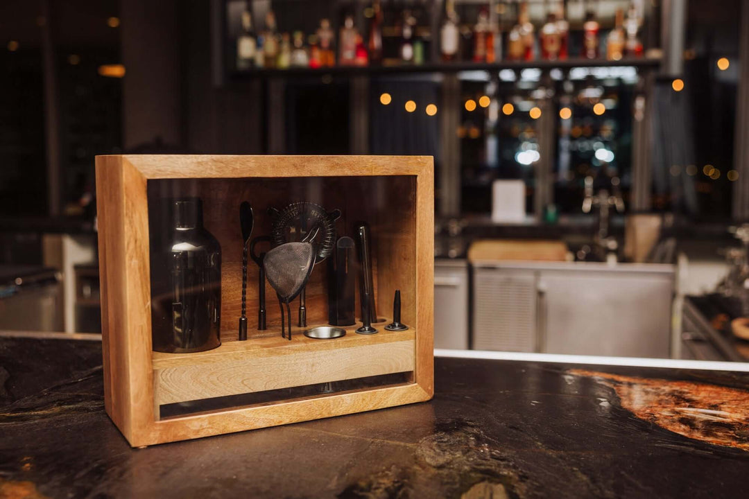 Vintage-Style Bartender Kit with Mango Wood Case & Bar Tools displayed on a bar counter in an elegant setting