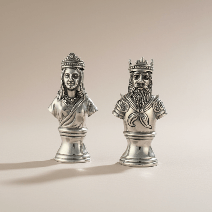 Silver busts of a king and queen on a beige background