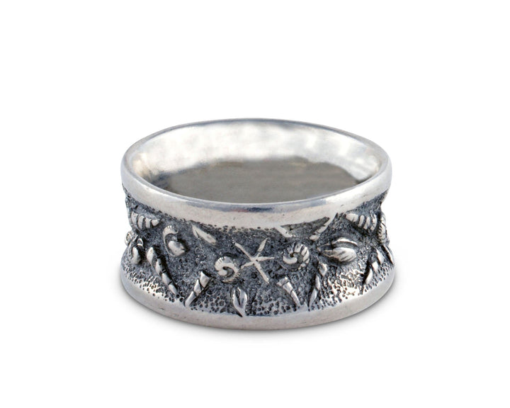 Silver napkin ring with embossed seashell design on a white background