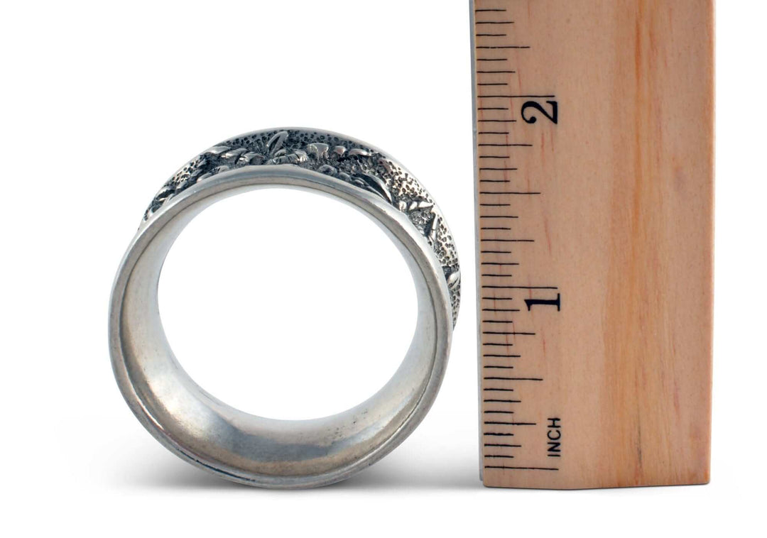 Silver napkin ring next to a wooden ruler for size reference