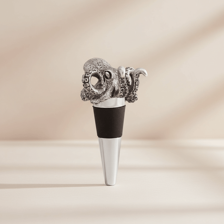 Metallic octopus-shaped bottle stopper on a beige background