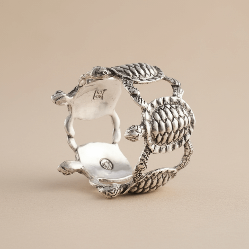 Silver napkin ring with turtle design on a beige background