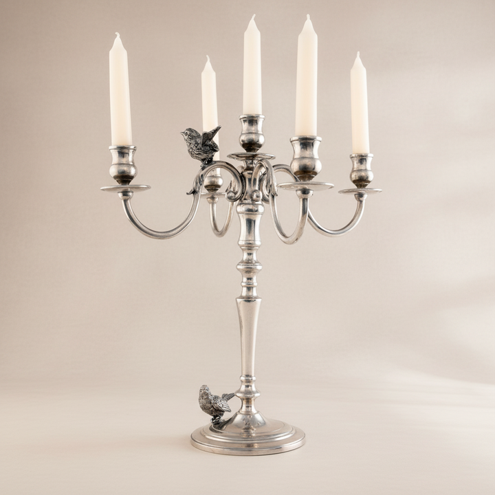 Silver candelabra with five candles on a beige background
