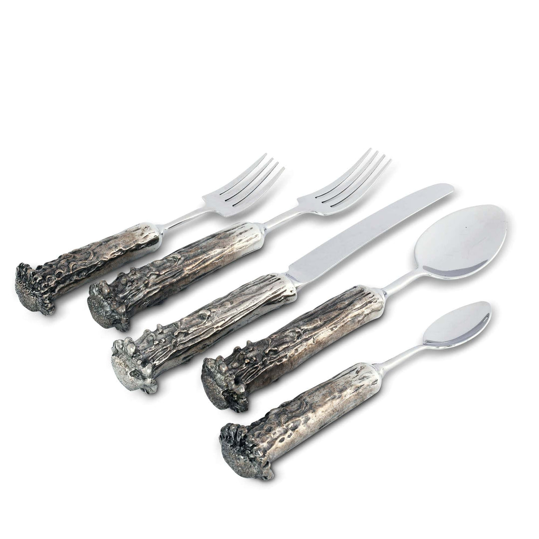 Set of silver cutlery with decorative handles on a white background