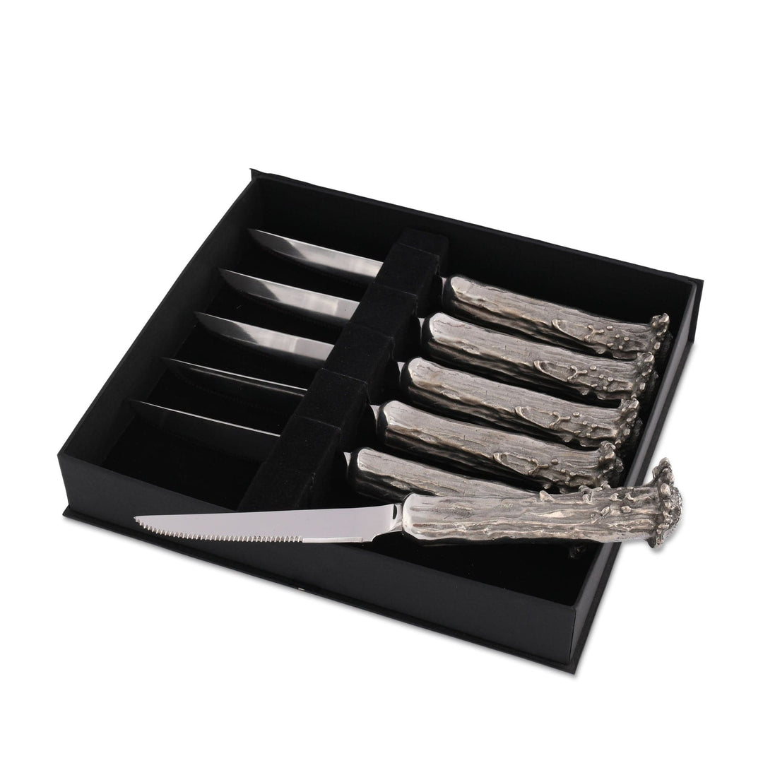 Set of decorative steak knives with antler handles in a black box on a white background