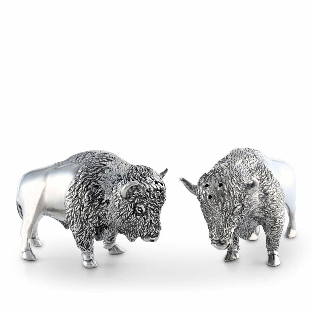 Two silver buffalo figurines on a white background