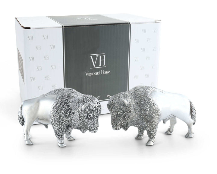 Two silver buffalo figurines in front of a Vagabond House branded box.