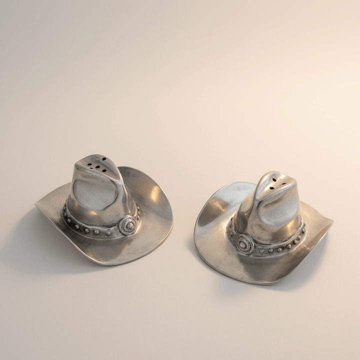 Pair of silver cowboy hat-shaped salt and pepper shakers on a light background