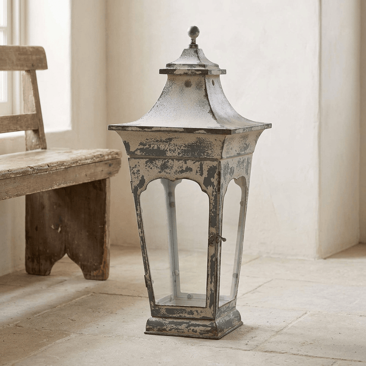 Large Vespera Iron Lantern on a pale stone entrance hall floor beside a wood bench