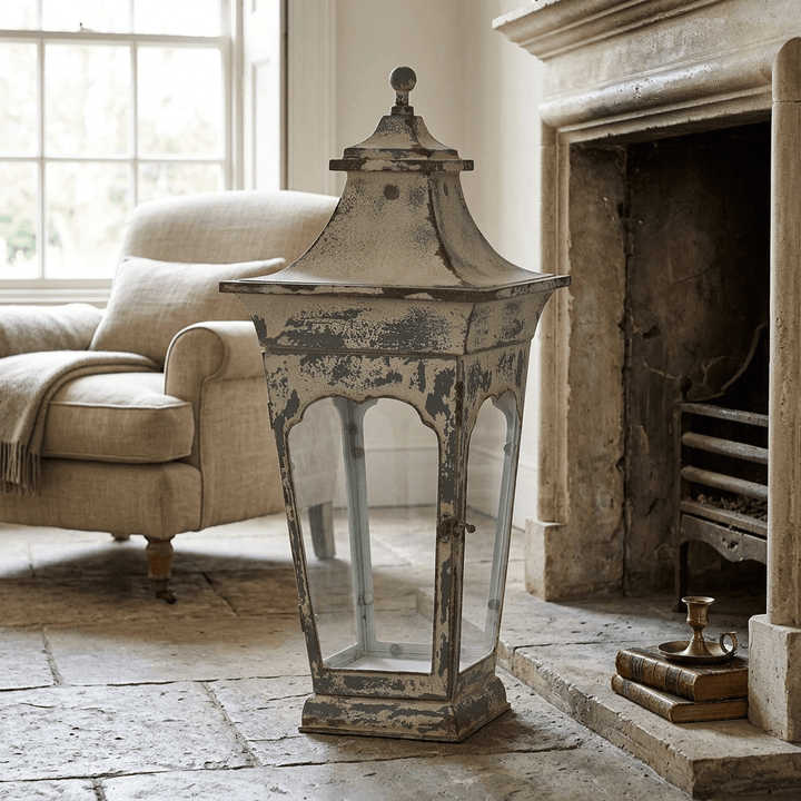 Large Vespera Iron Lantern on a stone floor beside a limestone fireplace