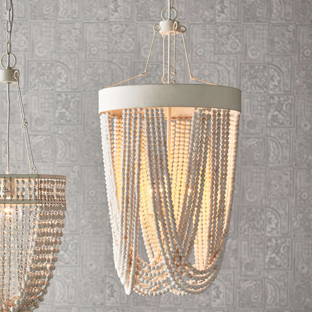 Vintage beaded chandelier with whitewashed wood beads, elegant coastal decor, and soft lighting.