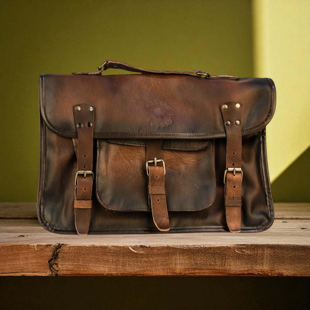 Vintage Brown Leather Laptop Bag with Twin Straps on a wooden surface.