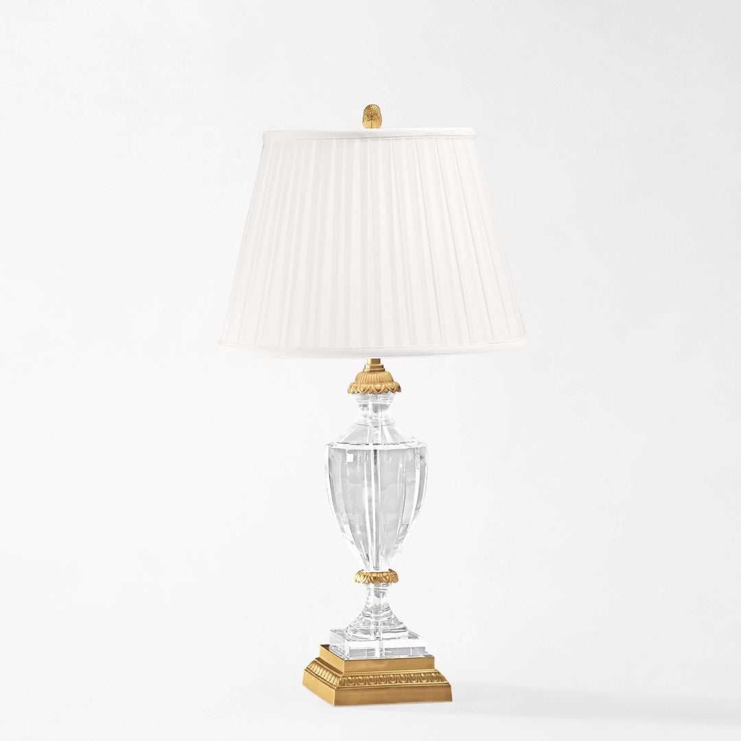 Decorative table lamp with clear glass base and gold accents on a white background