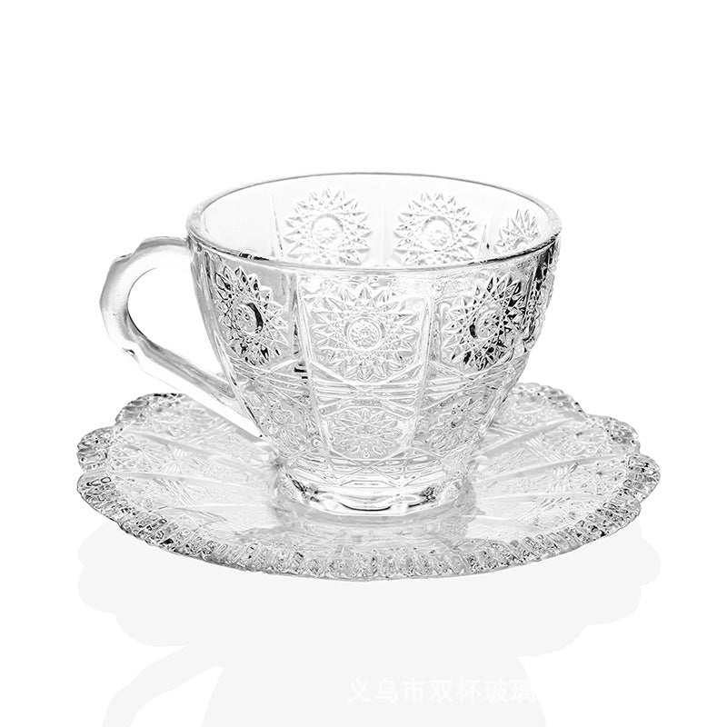 Close detail of the patterned teacup, curved handle, and matching saucer