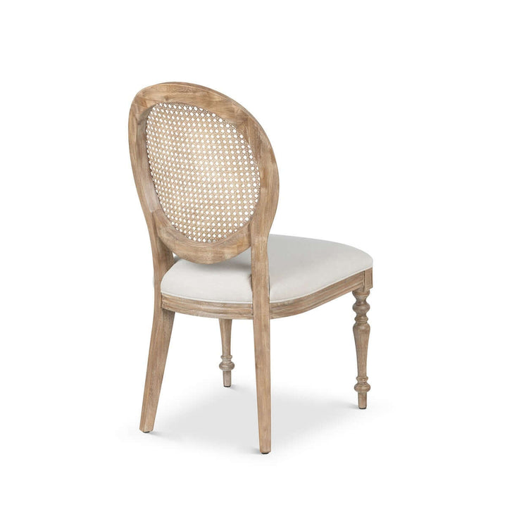 Back view of Vintage Farmhouse Cane Back Dining Chair with linen upholstery and hand-carved wooden legs.
