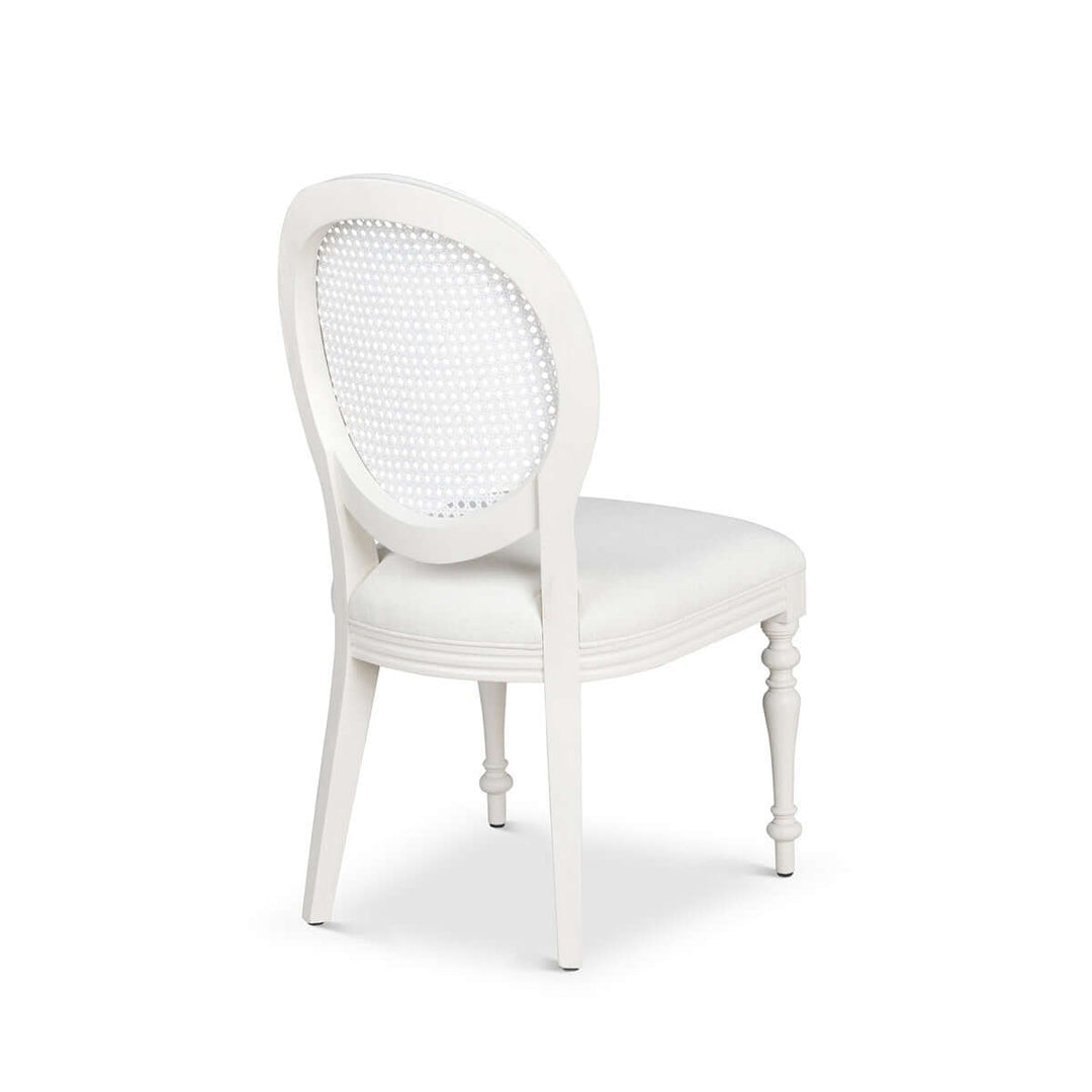 Vintage Farmhouse Cane Back Dining Chair with white upholstery and carved wooden legs, inspired by timeless European simplicity.