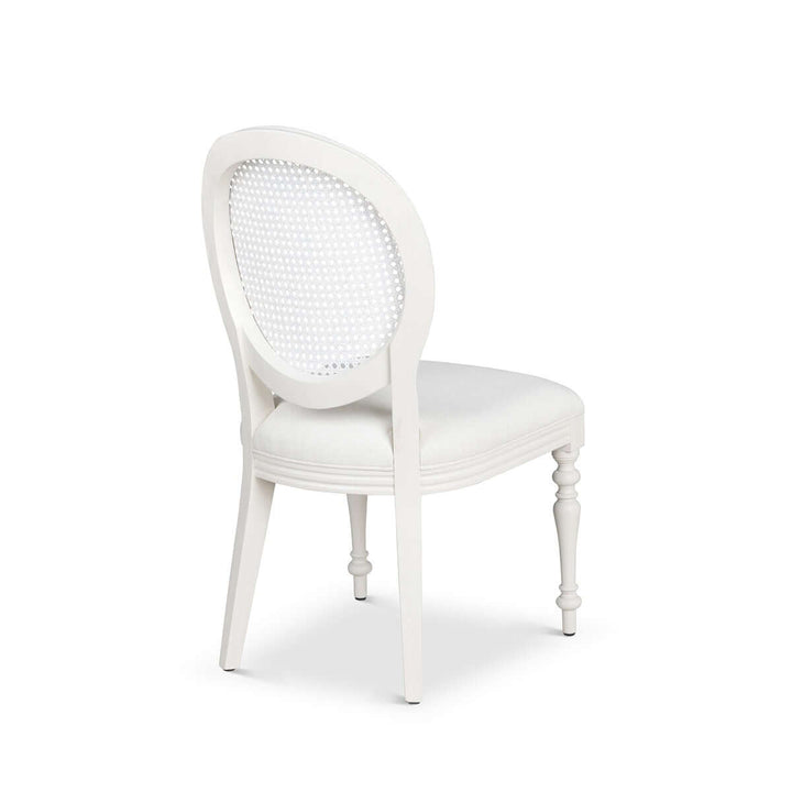 Vintage Farmhouse Cane Back Dining Chair with white upholstery and carved wooden legs, inspired by timeless European simplicity.