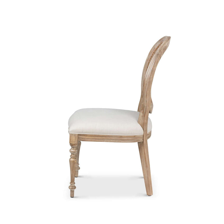 Side view of Vintage Farmhouse Cane Back Dining Chair with linen upholstery and hand-carved wood.