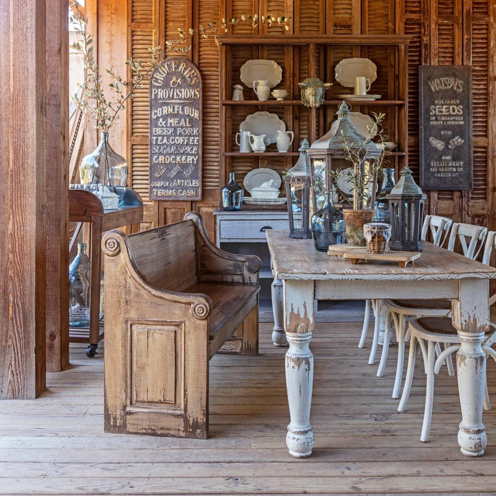 Rustic kitchen with Vintage Farmhouse Harvest Dining Table in Antique White and wooden bench seating in a cozy, warm setting.
