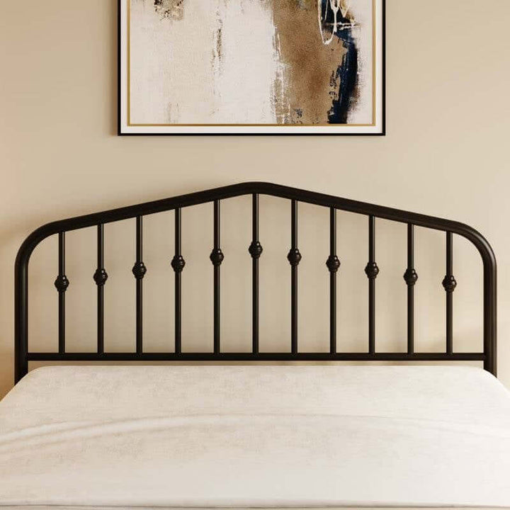 Vintage Farmhouse Spindle Black Metal Bed with arched headboard featuring classic spindle detailing against a beige wall with artwork.