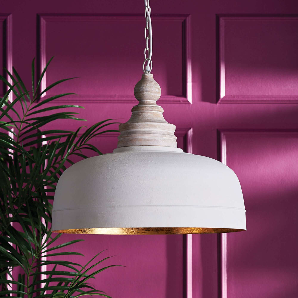 Vintage farmhouse white dome pendant light with wood finial, gold interior, hanging in a vibrant styled room.