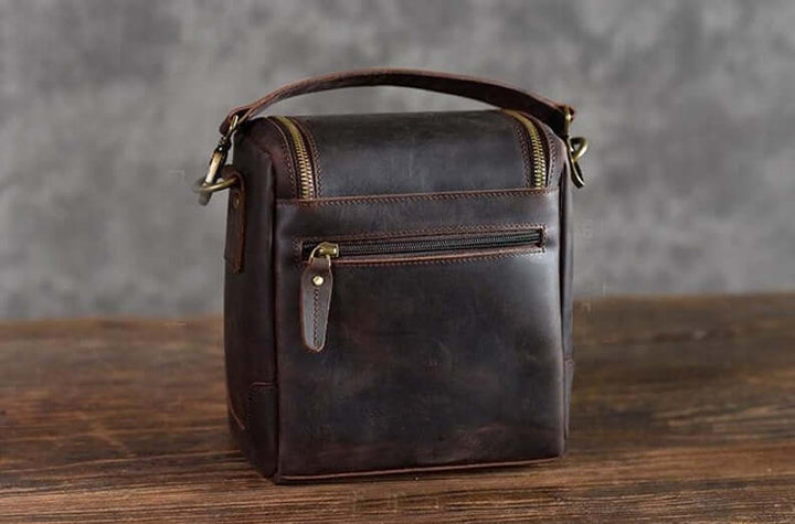 Vintage Full-Grain Leather Camera Bag The Calista on wooden table showcasing craftsmanship and timeless design.