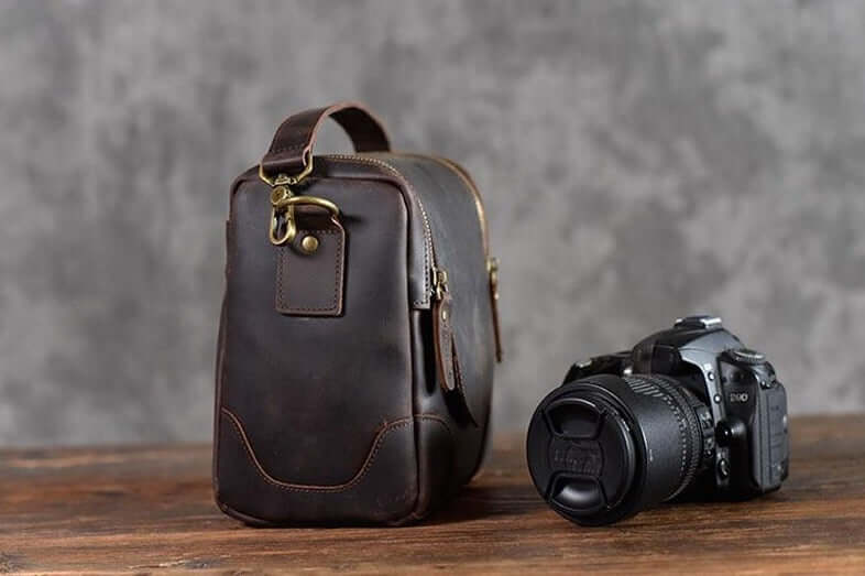 Vintage Full-Grain Leather Camera Bag next to DSLR camera on wooden table