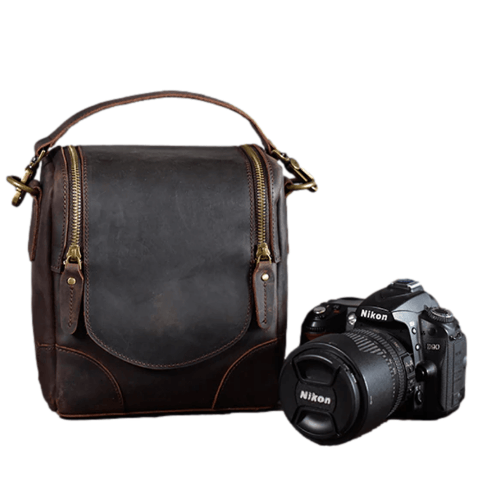 Vintage Full-Grain Leather Camera Bag next to a Nikon camera, showcasing classic craftsmanship and timeless design, also known as The Calista.