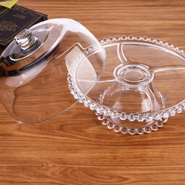 Vintage-inspired glass cake stand and cloche photographed on a clean background