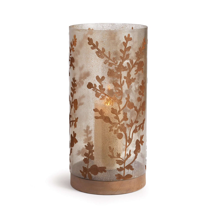 Vintage glass hurricane candle holder with botanical etching and warm candlelight glow.
