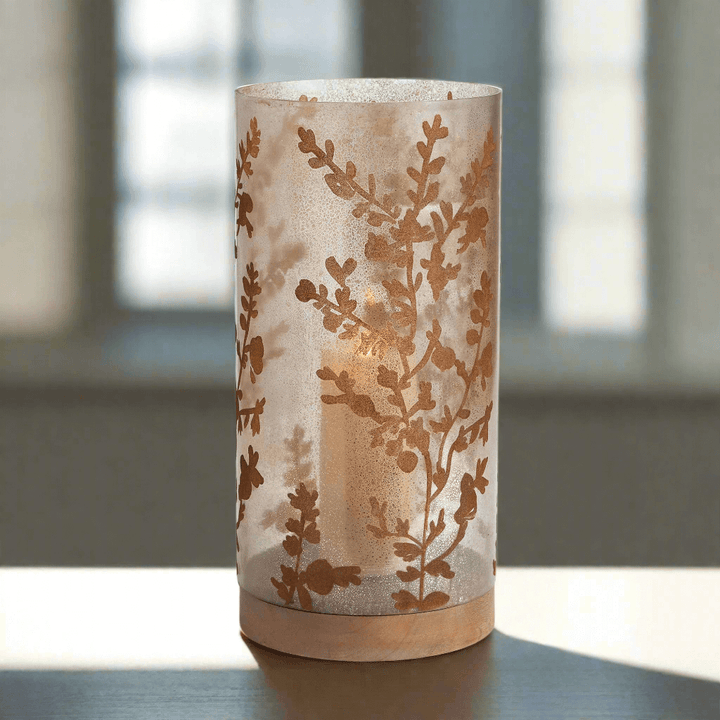 Vintage glass hurricane candle holder with botanical etching, showcasing soft candlelight and nature-inspired design.