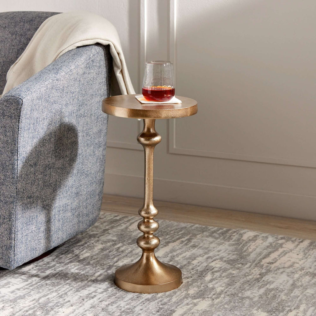 Vintage gold accent table with pedestal base, perfect for adding charm to a sitting nook or reading corner.