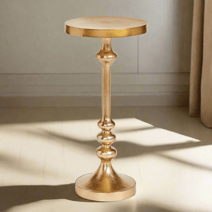 Vintage gold accent table with pedestal base, adding glamour to any sitting nook or reading corner.